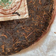 Load image into Gallery viewer, 2005 XingHai "Yin Kong Que - Gu Shu Qiao Mu" (Silvers Peacock - Menghai Old Arbor Tree) 501 Batch Cake 357g Puerh Ripe Tea Shou Cha
