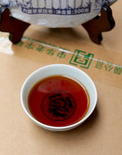 Load image into Gallery viewer, 500g Cake Dark Tea · Wuzhou, Guangxi**

Name: Liu Bao Tea – Pressed Cake “20060”
Brand: Sanhe (Three Cranes / Wuzhou Tea Factory)
Grade: Special Grade (Te Ji)
Form: Pressed Tea Cake
Specification: 500g per cake · 6 cakes per bundle · 24 cakes per carton
Aroma Profile: Betel-nut aroma · Fungal/“Golden Flower” floral aroma
Aging Start Date: December 25, 2020
Production Date: January 8, 2024

⸻

Product Description

The 20060 Liu Bao tea cake is produced by Wuzhou Tea Factory using carefully selected 2020 spri