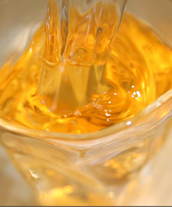 Clear glass cup with yellow liquid and text describing the tea's color and aroma.