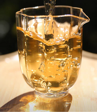 Load image into Gallery viewer, Glass teapot pouring tea with text on a black background