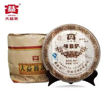 Load image into Gallery viewer, Chinese puerh tea cake with traditional packaging and Chinese characters, displayed on a stand