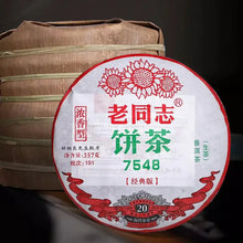 Charger l'image dans la galerie, Chinese puerh tea cake in traditional bamboo leaf wrapping, labeled 7548, with red and green Chinese text.