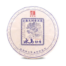 Load image into Gallery viewer, Chinese puerh tea cake wrapped in decorative paper with blue illustration and Chinese characters