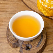 Load image into Gallery viewer, Cup of Chinese puerh tea with golden liquor on wooden coaster, traditional teaware