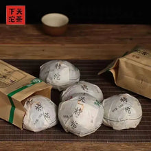 Load image into Gallery viewer, Chinese puerh tea cakes wrapped in paper with kraft bags on bamboo mat