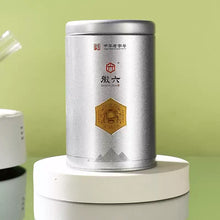 Load image into Gallery viewer, Silver canister of Liu Bao dark tea with Chinese label on green background