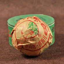 Carica l'immagine nel visualizzatore di Gallery, Wrapped puerh tea cake with Chinese text and bird design beside a green tea tin