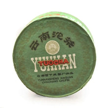 Carica l'immagine nel visualizzatore di Gallery, Yunnan Tuocha green paper-wrapped Chinese Pu-erh tea cake with bold text on packaging