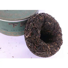 Charger l'image dans la galerie, Chinese puerh tea nest tuocha with green tin packaging, loose dark leaves visible