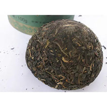 Charger l'image dans la galerie, Loose leaf Chinese Pu-erh tea ball on white background with green packaging