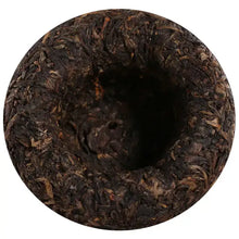 Carica l'immagine nel visualizzatore di Gallery, Close-up of a compressed Chinese puerh tea nest, showing dark tea leaves and textured surface.