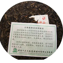 Carica l'immagine nel visualizzatore di Gallery, Close-up of loose leaf Chinese puerh tea with product label and tag in Chinese text