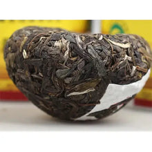 Load image into Gallery viewer, Close-up of a compressed Chinese puerh tea nest on a white surface