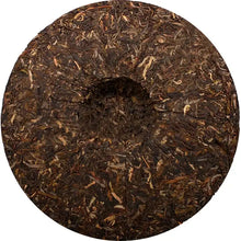 Load image into Gallery viewer, Compressed puerh tea cake with textured leaves and circular indentation, top view