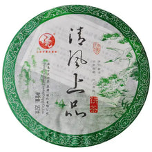 Load image into Gallery viewer, Chinese Pu-erh tea cake with green border, calligraphy, and nature illustration on wrapper