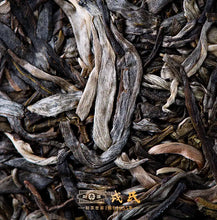 Load image into Gallery viewer, Close-up of loose leaf puerh tea with visible tea buds and leaves, Chinese text overlaid